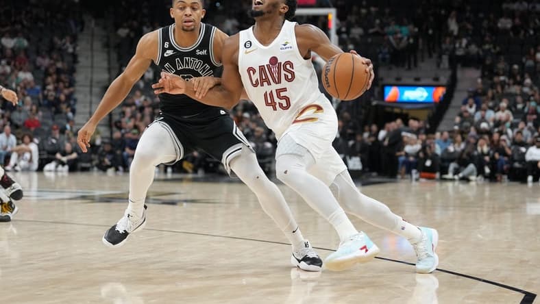 Dec 12, 2022; San Antonio, Texas, USA; Cleveland Cavaliers guard Donovan Mitchell (45) dribbles past San Antonio Spurs forward Keldon Johnson (3) in the second half at the AT&T Center. Mandatory Credit: Daniel Dunn-USA TODAY Sports
