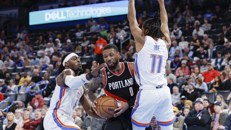 Dec 21, 2022; Oklahoma City, Oklahoma, USA; Portland Trail Blazers guard Damian Lillard (0) is defended by Oklahoma City Thunder guard Luguentz Dort (5) and guard Isaiah Joe (11) during the second quarter at Paycom Center. Mandatory Credit: Alonzo Adams-USA TODAY Sports