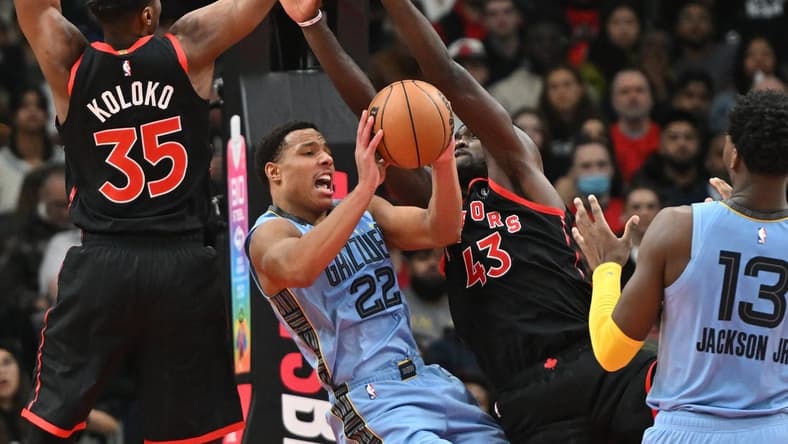 Dec 29, 2022; Toronto, Ontario, CAN;   Memphis Grizzlies forward Desmond Bane (22) tries to make a pass under the arms of Toronto Raptors center Christian Koloko (35) and forward Pascal Siakam (43) in the first half at Scotiabank Arena. Mandatory Credit: Dan Hamilton-USA TODAY Sports