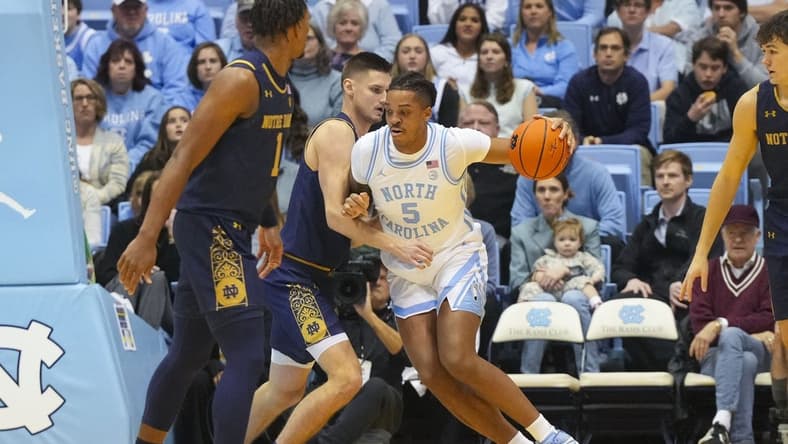 Jan 7, 2023; Chapel Hill, North Carolina, USA; North Carolina Tar Heels forward Armando Bacot (5) dribbles the ball against Notre Dame Fighting Irish forward Nate Laszewski (14) during the first half at Dean E. Smith Center. Mandatory Credit: James Guillory-USA TODAY Sports
