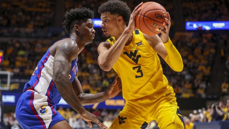 Jan 7, 2023; Morgantown, West Virginia, USA; West Virginia Mountaineers forward Tre Mitchell (3) pauses with the ball while defended by Kansas Jayhawks forward K.J. Adams Jr. (24) during the second half at WVU Coliseum. Mandatory Credit: Ben Queen-USA TODAY Sports