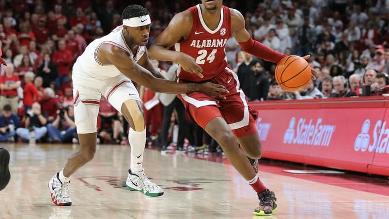 Jan 11, 2023; Fayetteville, Arkansas, USA; Alabama Crimson Tide forward Brandon Miller (24) dribbles by Arkansas Razorbacks guard Davonte Davis (4) during the first half at Bud Walton Arena. Mandatory Credit: Nelson Chenault-USA TODAY Sports