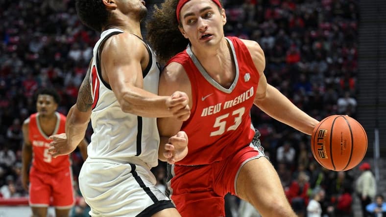 Jan 14, 2023; San Diego, California, USA; New Mexico Lobos forward Josiah Allick (53) dribbles the ball while defended by San Diego State Aztecs guard Matt Bradley (20) during the second half at Viejas Arena. Mandatory Credit: Orlando Ramirez-USA TODAY Sports