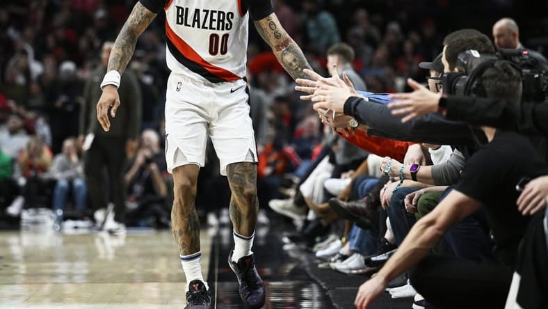 Jan 14, 2023; Portland, Oregon, USA; Portland Trail Blazers guard Gary Payton II (00) gives fans high-fives during the first half against the Dallas Mavericks at Moda Center. Mandatory Credit: Troy Wayrynen-USA TODAY Sports