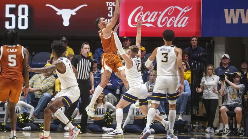 Jan 21, 2023; Morgantown, West Virginia, USA; Texas Longhorns forward Timmy Allen (0) shoots over West Virginia Mountaineers guard Erik Stevenson (10) during the second half at WVU Coliseum. Mandatory Credit: Ben Queen-USA TODAY Sports