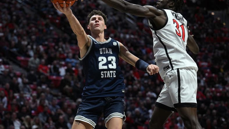 Jan 25, 2023; San Diego, California, USA; Utah State Aggies forward Taylor Funk (23) shoots the ball past San Diego State Aztecs forward Nathan Mensah (31) during the second half at Viejas Arena. Mandatory Credit: Orlando Ramirez-USA TODAY Sports