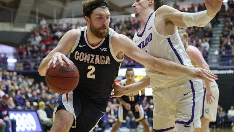 Jan 28, 2023; Portland, Oregon, USA; Gonzaga Bulldogs forward Drew Timme (2) drives to the basket against Portland Pilots forward Moses Wood (1) during the second half at Chiles Center. Mandatory Credit: Troy Wayrynen-USA TODAY Sports