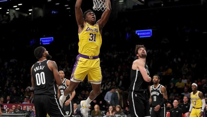 Jan 30, 2023; Brooklyn, New York, USA; Los Angeles Lakers center Thomas Bryant (31) dunks against Brooklyn Nets forwards Royce O'Neale (00) and Joe Harris (12) during the third quarter at Barclays Center. Mandatory Credit: Brad Penner-USA TODAY Sports