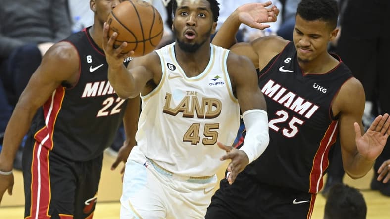 Jan 31, 2023; Cleveland, Ohio, USA; Cleveland Cavaliers guard Donovan Mitchell (45) drives to the basket past Miami Heat forward Jimmy Butler (22) and center Orlando Robinson (25) in the third quarter at Rocket Mortgage FieldHouse. Mandatory Credit: David Richard-USA TODAY Sports