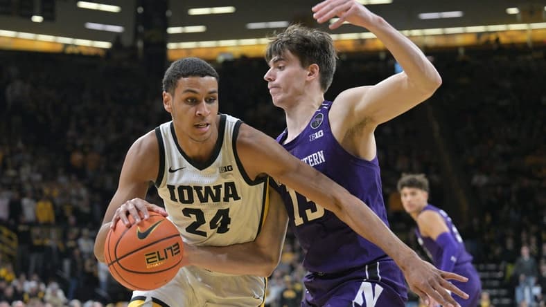 Jan 31, 2023; Iowa City, Iowa, USA; Iowa Hawkeyes forward Kris Murray (24) goes to the basket as Northwestern Wildcats guard Brooks Barnhizer (13) defends during the second half at Carver-Hawkeye Arena. Mandatory Credit: Jeffrey Becker-USA TODAY Sports