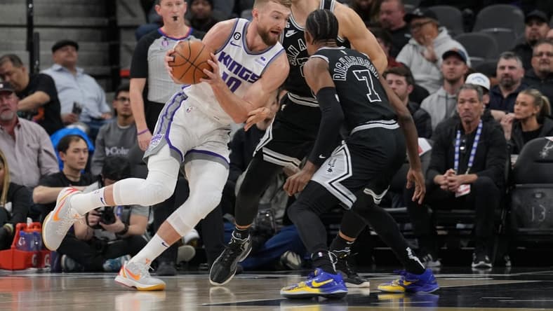 Feb 1, 2023; San Antonio, Texas, USA;  Sacramento Kings forward Domantas Sabonis (10) drives around San Antonio Spurs forward Zach Collins (23) in the first half at the AT&T Center. Mandatory Credit: Daniel Dunn-USA TODAY Sports