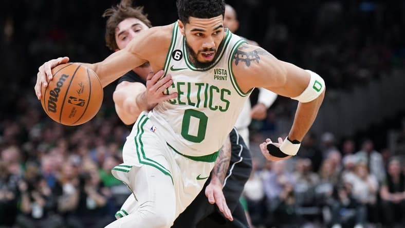 Feb 1, 2023; Boston, Massachusetts, USA; Boston Celtics forward Jayson Tatum (0) drives the ball against Brooklyn Nets forward Joe Harris (12) in the first quarter at TD Garden. Mandatory Credit: David Butler II-USA TODAY Sports