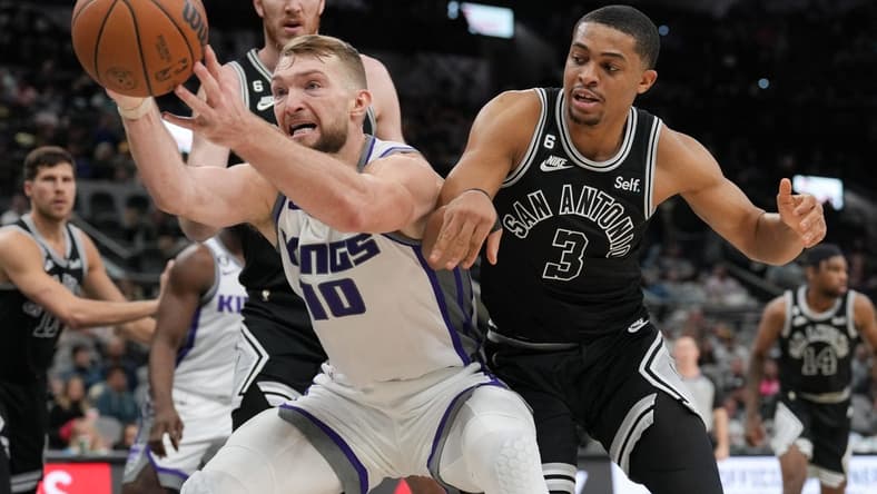 Feb 1, 2023; San Antonio, Texas, USA; Sacramento Kings forward Domantas Sabonis (10) reaches for a ball in front of San Antonio Spurs forward Keldon Johnson (3) in the second half at the AT&T Center. Mandatory Credit: Daniel Dunn-USA TODAY Sports