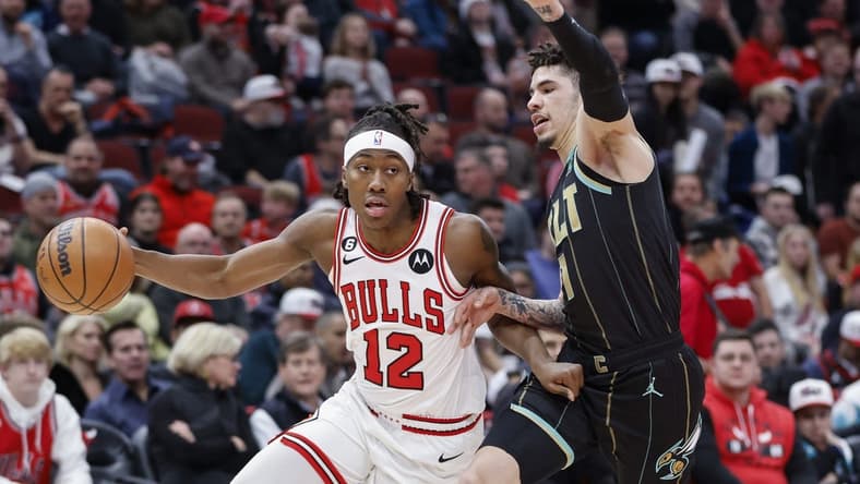 Feb 2, 2023; Chicago, Illinois, USA; Chicago Bulls guard Ayo Dosunmu (12) drives to the basket against Charlotte Hornets guard LaMelo Ball (1) during the first half at United Center. Mandatory Credit: Kamil Krzaczynski-USA TODAY Sports
