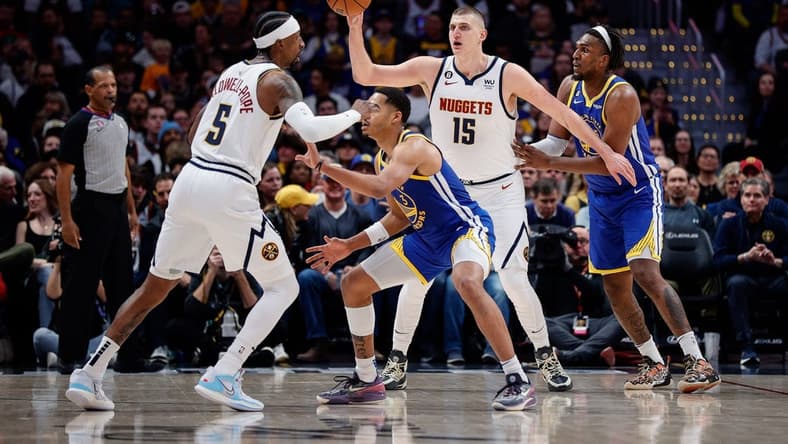 Feb 2, 2023; Denver, Colorado, USA; Denver Nuggets center Nikola Jokic (15) controls the ball against Golden State Warriors forward Kevon Looney (5) as guard Kentavious Caldwell-Pope (5) and guard Jordan Poole (3) battle for position in the first quarter at Ball Arena. Mandatory Credit: Isaiah J. Downing-USA TODAY Sports