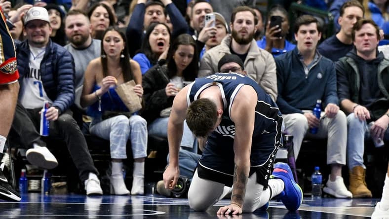 Feb 2, 2023; Dallas, Texas, USA; Dallas Mavericks guard Luka Doncic (77) kneels on the floor after he is fouled by New Orleans Pelicans forward Brandon Ingram (not pictured) as he drives to the basket during the second half at the American Airlines Center. Mandatory Credit: Jerome Miron-USA TODAY Sports