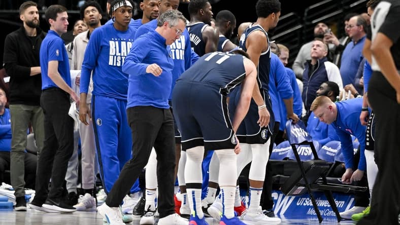 Feb 2, 2023; Dallas, Texas, USA; Dallas Mavericks guard Luka Doncic (77) is checked by a team trainer after he is fouled by New Orleans Pelicans forward Brandon Ingram (not pictured) as he drives to the basket during the second half at the American Airlines Center. Mandatory Credit: Jerome Miron-USA TODAY Sports