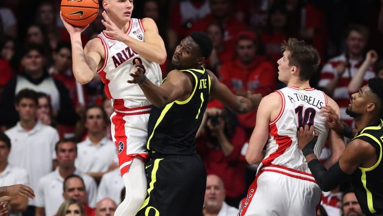 Feb 2, 2023; Tucson, Arizona, USA; Arizona Wildcats guard Pelle Larsson (3) makes a pass against Oregon Ducks center N'Faly Dante (1) to Arizona Wildcats forward Azuolas Tubelis (10) in the first hall at McKale Center. Mandatory Credit: Zachary BonDurant-USA TODAY Sports