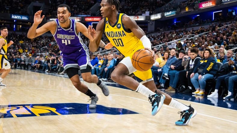 Feb 3, 2023; Indianapolis, Indiana, USA; Indiana Pacers guard Bennedict Mathurin (00) dribbles the ball while Sacramento Kings forward Trey Lyles (41) defends in the second quarter at Gainbridge Fieldhouse. Mandatory Credit: Trevor Ruszkowski-USA TODAY Sports