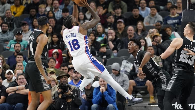 Feb 3, 2023; San Antonio, Texas, USA; Philadelphia 76ers guard Shake Milton (18) shoots over San Antonio Spurs forwards Stanley Johnson (34) and Zach Collins (23) during the first half at AT&T Center. Mandatory Credit: Scott Wachter-USA TODAY Sports