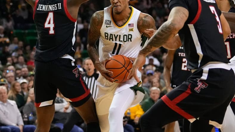 Feb 4, 2023; Waco, Texas, USA; Baylor Bears forward Jalen Bridges (11) drives to the basket between Texas Tech Red Raiders forward Robert Jennings (4) and guard D'Maurian Williams (3) during the first half at Ferrell Center. Mandatory Credit: Chris Jones-USA TODAY Sports