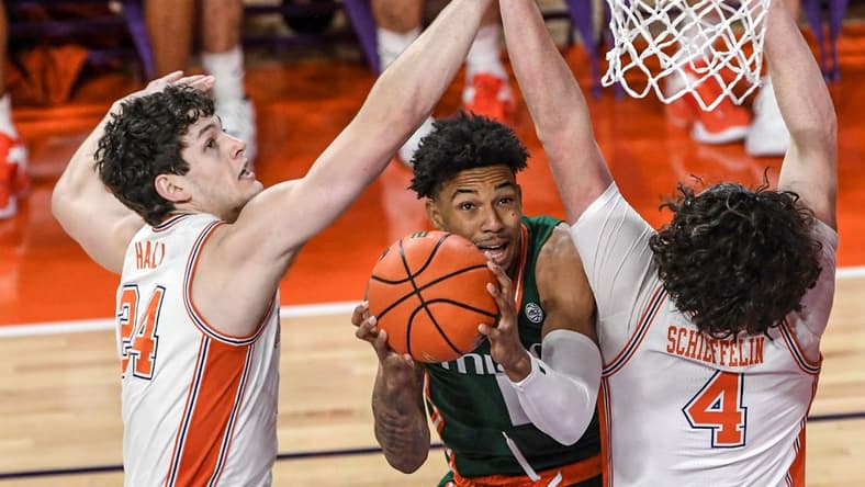Feb 4, 2023; Clemson, South Carolina, USA; Miami guard Jordan Miller (11) shoots around Clemson sophomore forward PJ Hall (24) and Clemson sophomore forward Ian Schieffelin (4) during the first half at Littlejohn Coliseum in Clemson, S.C. Saturday, Feb. 4, 2023. Mandatory Credit: Ken Ruinard-USA TODAY Sports