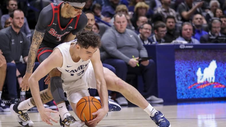 Feb 4, 2023; Cincinnati, Ohio, USA; Xavier Musketeers guard Kam Craft (12) battles for the ball against St. John's Red Storm guard Andre Curbelo (3) in the first half at Cintas Center. Mandatory Credit: Katie Stratman-USA TODAY Sports