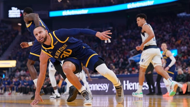 Feb 4, 2023; San Francisco, California, USA; Golden State Warriors guard Stephen Curry (30) regains his footing after being knocked to the ground against the Dallas Mavericks in the first quarter at the Chase Center. Mandatory Credit: Cary Edmondson-USA TODAY Sports
