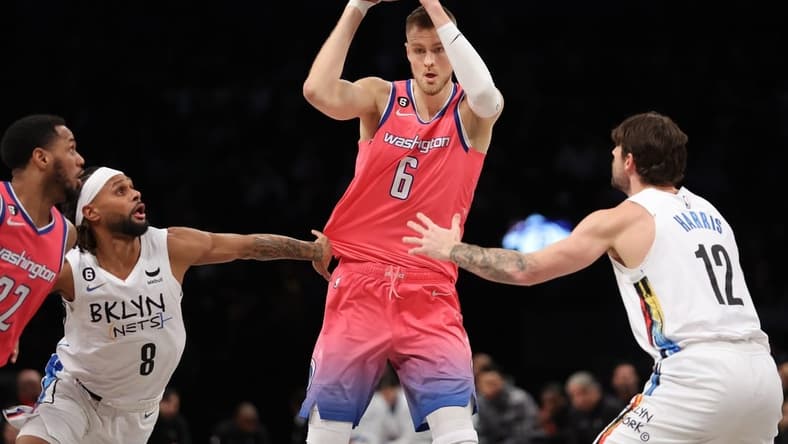Feb 4, 2023; Brooklyn, New York, USA; Washington Wizards center Kristaps Porzingis (6) controls the ball against Brooklyn Nets guard Patty Mills (8) and forward Joe Harris (12) during the third quarter at Barclays Center. Mandatory Credit: Brad Penner-USA TODAY Sports