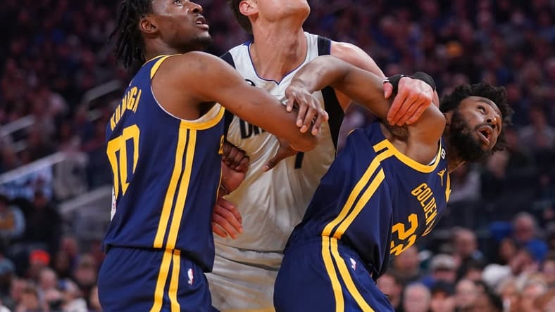 Feb 4, 2023; San Francisco, California, USA; Dallas Mavericks center Dwight Powell (7) battles for position against Golden State Warriors forward Jonathan Kuminga (00) and forward Andrew Wiggins (22) in the second quarter at the Chase Center. Mandatory Credit: Cary Edmondson-USA TODAY Sports