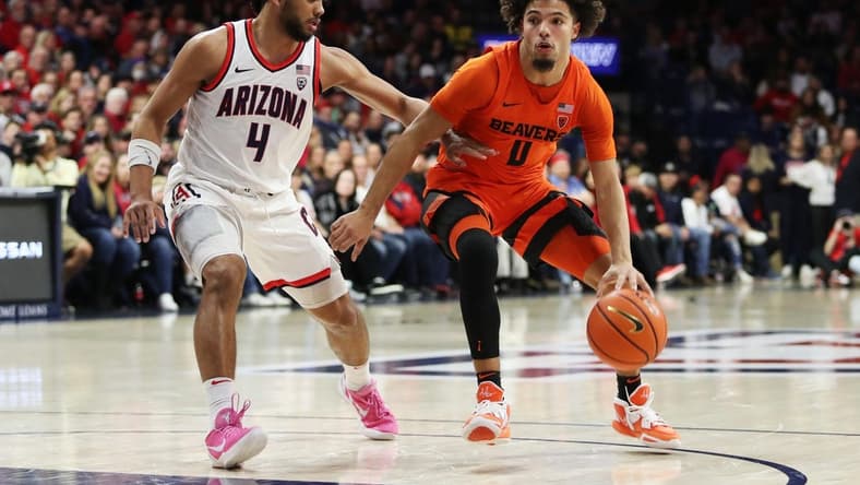 Feb 4, 2023; Tucson, Arizona, USA; Oregon State Beavers guard Jordan Pope (0) drives to the net against Arizona Wildcats guard Kylan Boswell (4) in the first half at McKale Center. Mandatory Credit: Zachary BonDurant-USA TODAY Sports