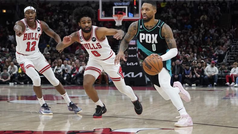 Feb 4, 2023; Chicago, Illinois, USA; Portland Trail Blazers guard Damian Lillard (0) drives to the basket against Chicago Bulls guard Coby White (0) and guard Ayo Dosunmu (12) during the second half at United Center. Mandatory Credit: David Banks-USA TODAY Sports