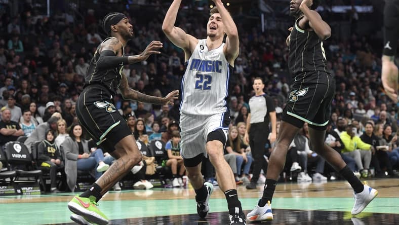 Feb 5, 2023; Charlotte, North Carolina, USA; Orlando Magic forward Franz Wagner (22) drives past Charlotte Hornets forward Jalen McDaniels (6) and center Mark Williams (5) during the first half at the Spectrum Center. Mandatory Credit: Sam Sharpe-USA TODAY Sports
