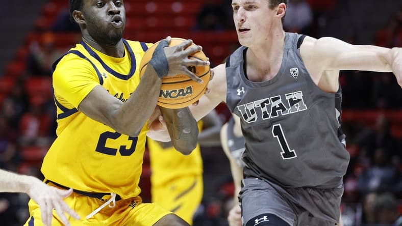 Feb 5, 2023; Salt Lake City, Utah, USA; California Golden Bears forward Obinna Anyanwu (23) drives against Utah Utes forward Ben Carlson (1) in the first half at Jon M. Huntsman Center. Mandatory Credit: Jeffrey Swinger-USA TODAY Sports