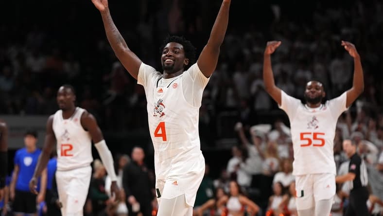 Feb 6, 2023; Coral Gables, Florida, USA; Miami Hurricanes guard Bensley Joseph (4), center Favour Aire (12) and guard Wooga Poplar (55) celebrate after defeating the Duke Blue Devils at Watsco Center. Mandatory Credit: Jasen Vinlove-USA TODAY Sports