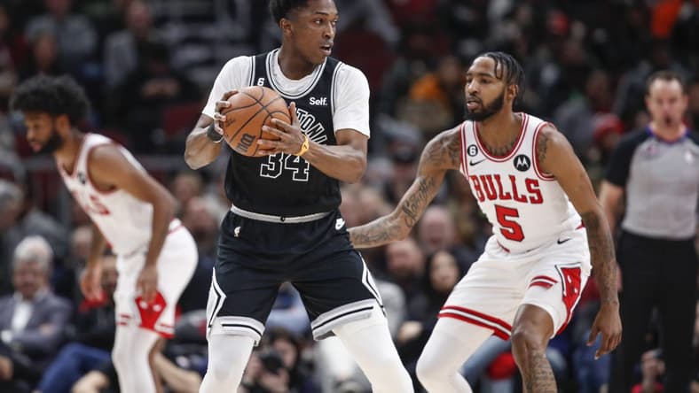 Feb 6, 2023; Chicago, Illinois, USA; San Antonio Spurs forward Stanley Johnson (34) looks to pass the ball against Chicago Bulls forward Derrick Jones Jr. (5) during the first half at United Center. Mandatory Credit: Kamil Krzaczynski-USA TODAY Sports