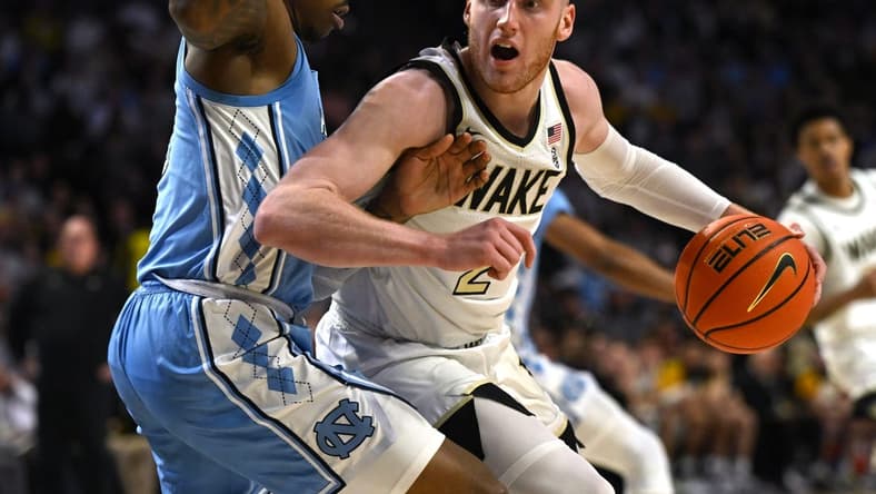 Feb 7, 2023; Winston-Salem, North Carolina, USA; Wake Forest Demon Deacons guard Cameron Hildreth (2) spins on North Carolina Tar Heels guard Caleb Love (2) during the first half at Lawrence Joel Veterans Memorial Coliseum. Mandatory Credit: William Howard-USA TODAY Sports