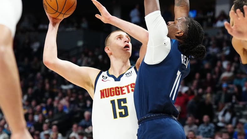 Feb 7, 2023; Denver, Colorado, USA; Denver Nuggets center Nikola Jokic (15) shoots the ball at Minnesota Timberwolves center Naz Reid (11) in the first quarter at Ball Arena. Mandatory Credit: Ron Chenoy-USA TODAY Sports