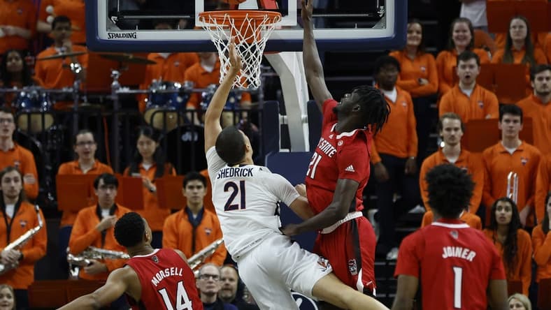 Feb 7, 2023; Charlottesville, Virginia, USA; Virginia Cavaliers forward Kadin Shedrick (21) is fouled while shooting by North Carolina State Wolfpack forward Ebenezer Dowuona (21) in the first half at John Paul Jones Arena. Mandatory Credit: Geoff Burke-USA TODAY Sports
