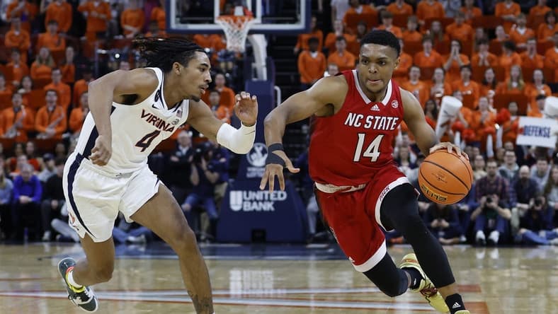 Feb 7, 2023; Charlottesville, Virginia, USA; North Carolina State Wolfpack guard Casey Morsell (14) drives to the basket as Virginia Cavaliers guard Armaan Franklin (4) defends in the first half at John Paul Jones Arena. Mandatory Credit: Geoff Burke-USA TODAY Sports