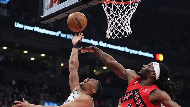 Feb 8, 2023; Toronto, Ontario, CAN; San Antonio Spurs forward Keldon Johnson (3) drives to the basket as Toronto Raptors forward Precious Achiuwa (5) tries to defend during the first quarter at Scotiabank Arena. Mandatory Credit: Nick Turchiaro-USA TODAY Sports