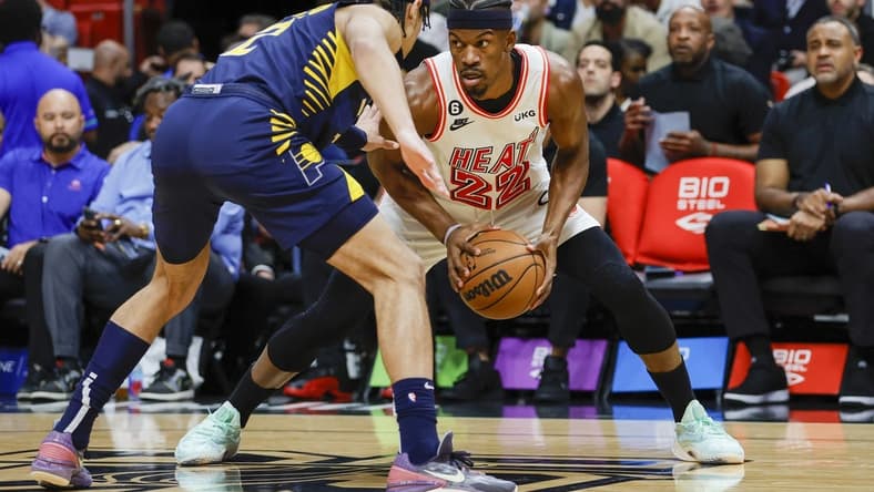 Feb 8, 2023; Miami, Florida, USA; Miami Heat forward Jimmy Butler (22) protects the ball from Indiana Pacers guard Andrew Nembhard (2) during the first quarter at Miami-Dade Arena. Mandatory Credit: Sam Navarro-USA TODAY Sports
