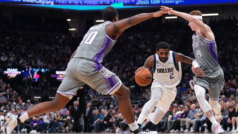 Feb 10, 2023; Sacramento, California, USA; Dallas Mavericks guard Kyrie Irving (2) dribbles between Sacramento Kings guard Kevin Huerter (9) and forward Harrison Barnes (40) in the second quarter at the Golden 1 Center. Mandatory Credit: Cary Edmondson-USA TODAY Sports