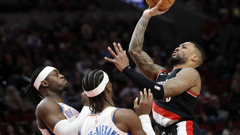 Feb 10, 2023; Portland, Oregon, USA; Portland Trail Blazers point guard Damian Lillard (0, right) is fouled while shooting by Oklahoma City Thunder point guard Shai Gilgeous-Alexander (2, left) during the first half at Moda Center. Mandatory Credit: Soobum Im-USA TODAY Sports