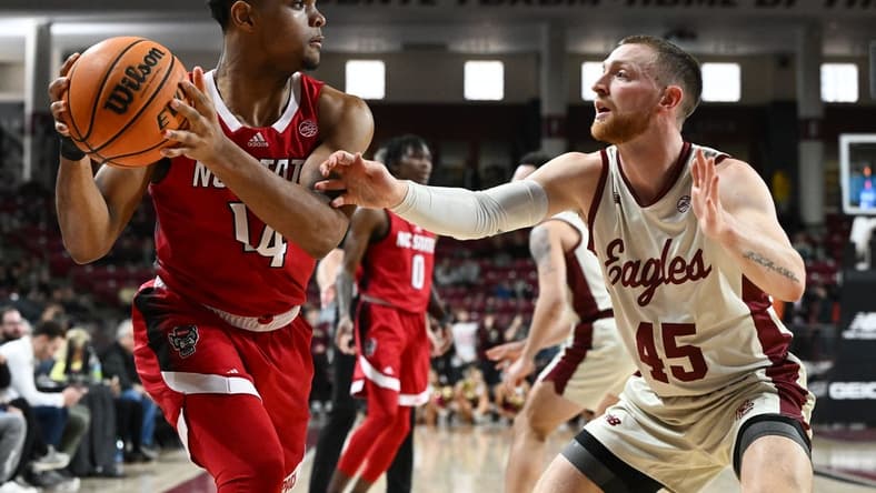 Feb 11, 2023; Chestnut Hill, Massachusetts, USA; North Carolina State Wolfpack guard Casey Morsell (14) controls the ball against Boston College Eagles guard Mason Madsen (45) during the first half at the Conte Forum. Mandatory Credit: Brian Fluharty-USA TODAY Sports