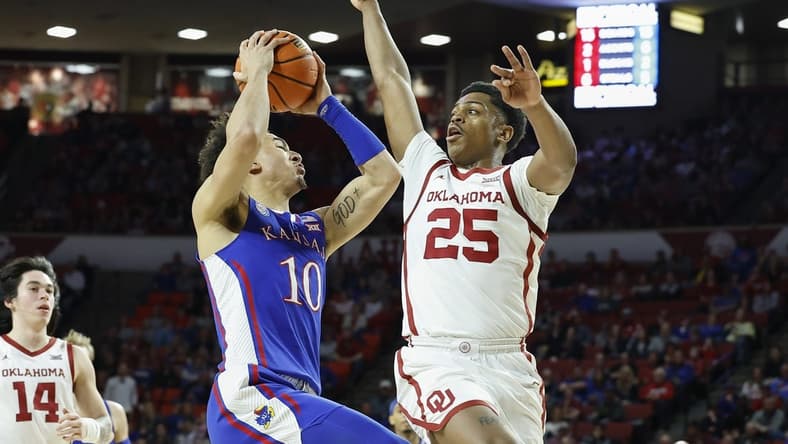 Feb 11, 2023; Norman, Oklahoma, USA; Kansas Jayhawks forward Jalen Wilson (10) drives against Oklahoma Sooners guard Grant Sherfield (25) during the first half at Lloyd Noble Center. Mandatory Credit: Alonzo Adams-USA TODAY Sports