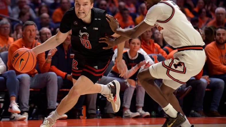 Feb 11, 2023; Champaign, Illinois, USA; Rutgers Scarlet Knights guard Cam Spencer (10) drives the ball as Illinois Fighting Illini guard Sencire Harris (1) defends during the second half at State Farm Center. Mandatory Credit: Ron Johnson-USA TODAY Sports