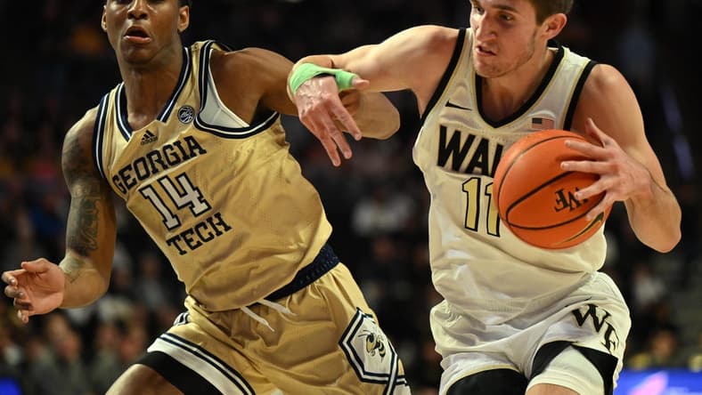 Feb 11, 2023; Winston-Salem, North Carolina, USA; Wake Forest Demon Deacons forward Andrew Carr (11) battles around Georgia Tech Yellow Jackets forward Jalon Moore (14) during the first half at Lawrence Joel Veterans Memorial Coliseum. Mandatory Credit: William Howard-USA TODAY Sports
