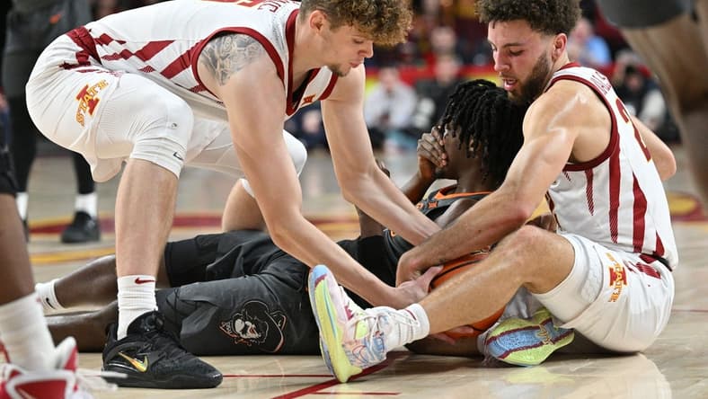 Feb 11, 2023; Ames, Iowa, USA; Iowa State Cyclones guard Gabe Kalscheur (right) and forward Aljaz Kunc (5) battle Oklahoma State Cowboys guard Caleb Asberry (5) for a loose ball during the first half at James H. Hilton Coliseum. Asberry would be injured on the play. Mandatory Credit: Jeffrey Becker-USA TODAY Sports