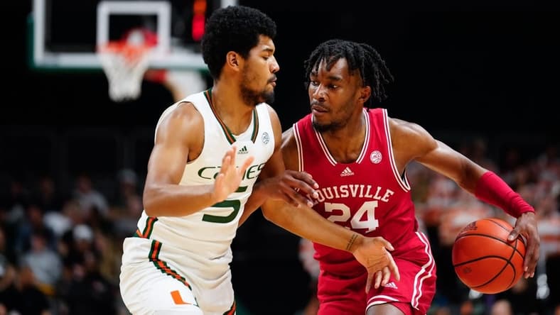 Feb 11, 2023; Coral Gables, Florida, USA; Louisville Cardinals forward Jae'Lyn Withers (24) dibbles the ball past Miami (Fl) Hurricanes guard Harlond Beverly (5) during the first half at Watsco Center. Mandatory Credit: Rich Storry-USA TODAY Sports